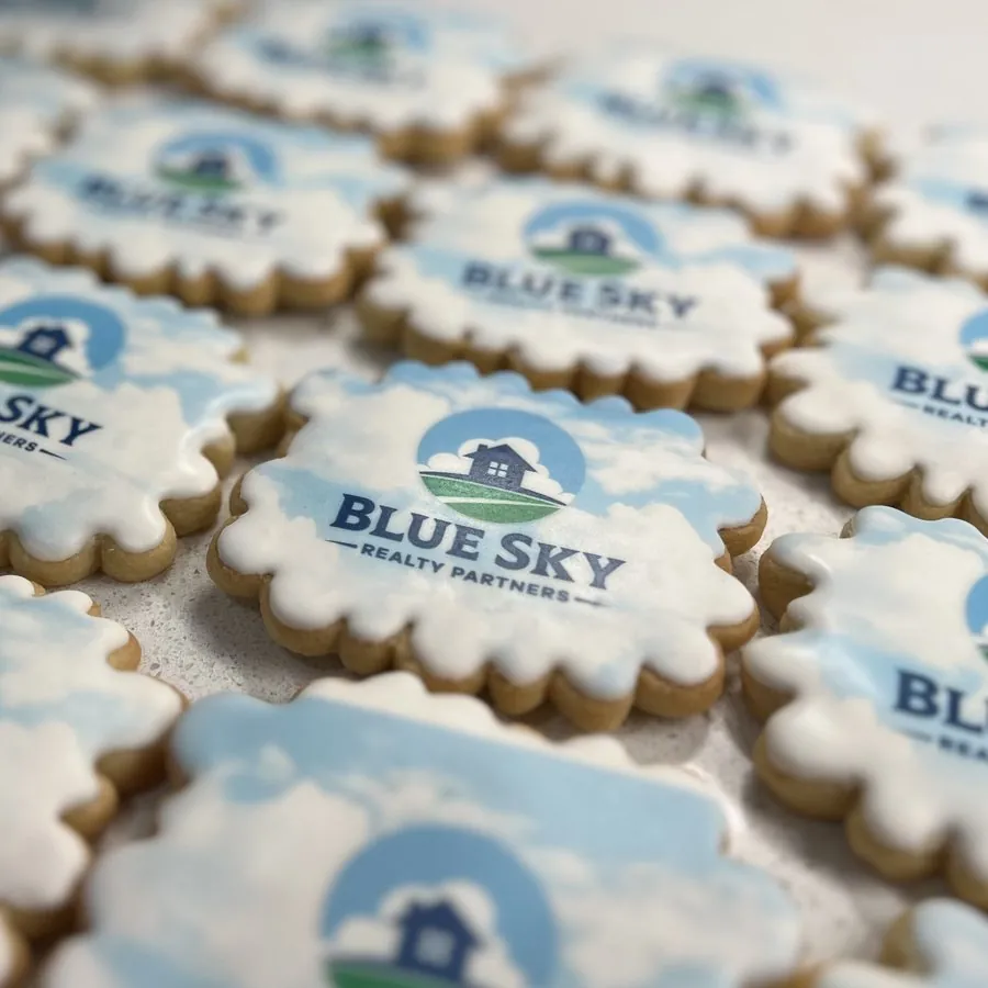 Cookie printed with the Blue Sky Realty Partners logo, framed in white royal icing