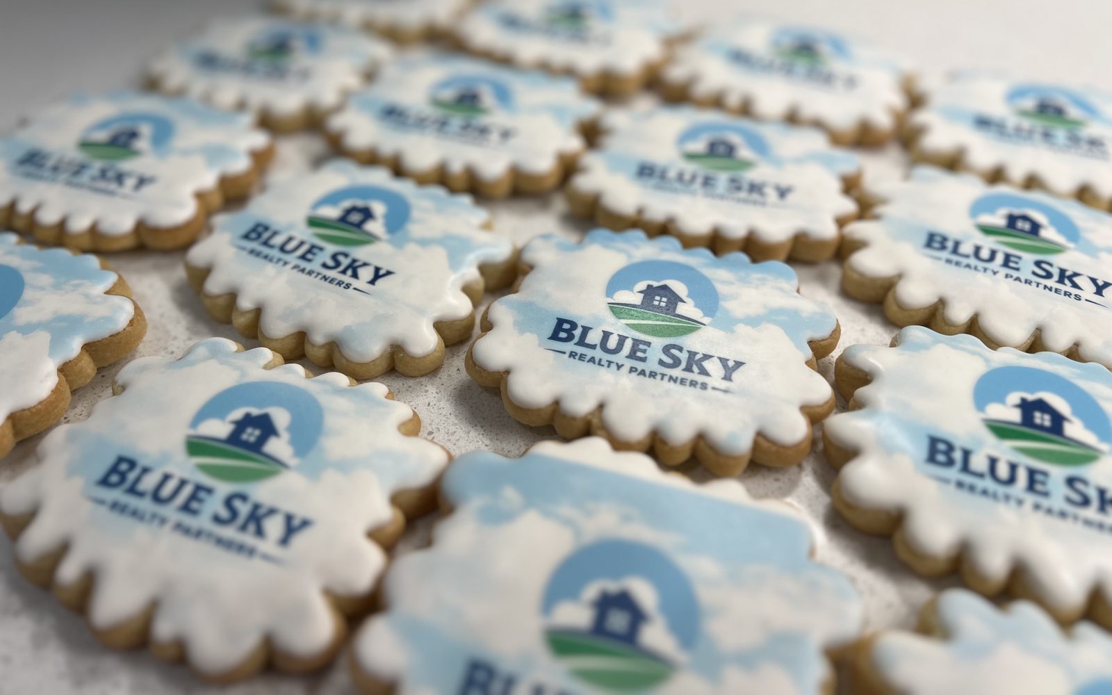 Scalloped cookies printed with the Blue Sky Realty Partners logo